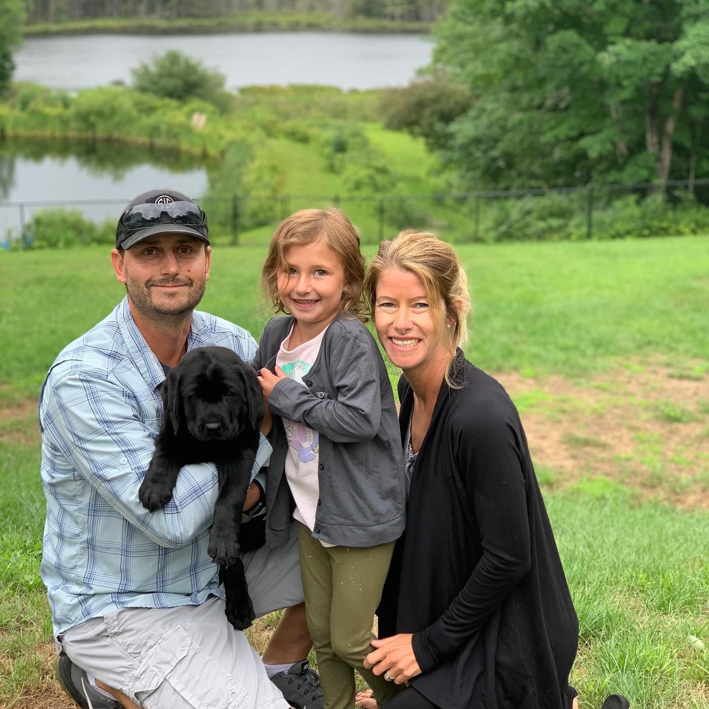 Happy family with their retriever puppy